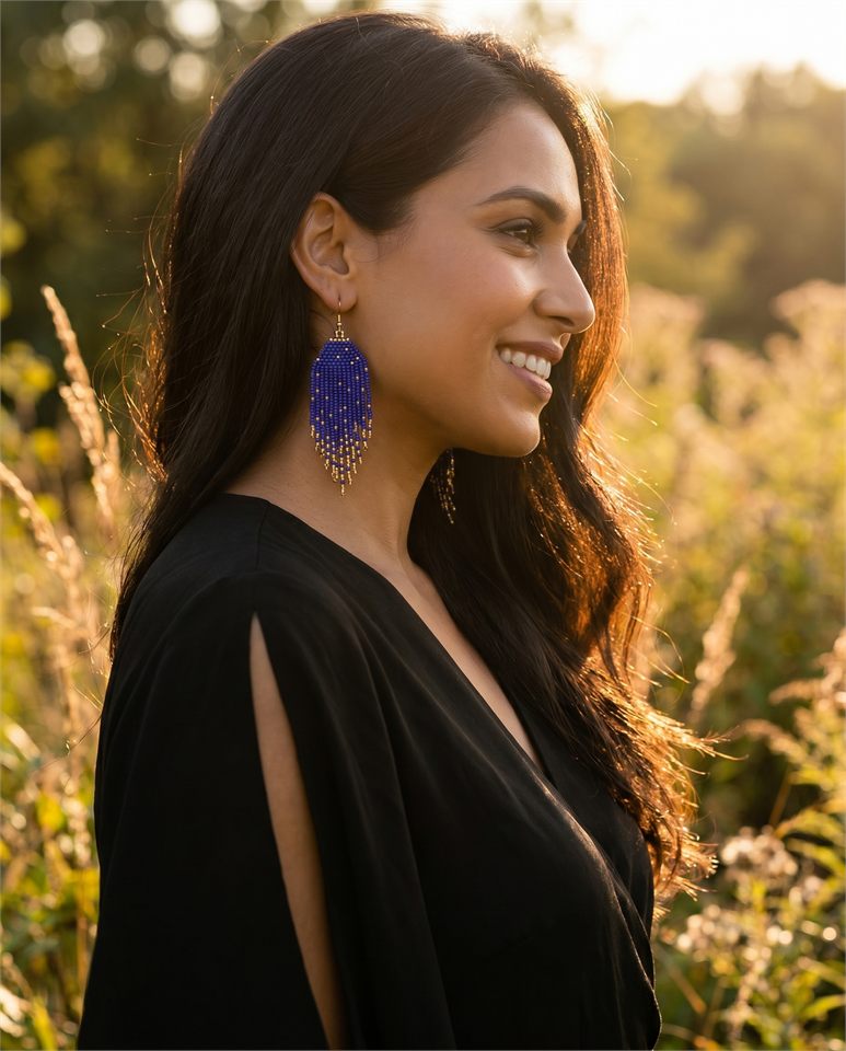 Blue beaded earrings worn outdoors